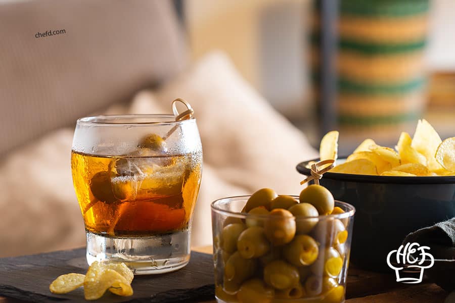 vermouth drink with olive and chips