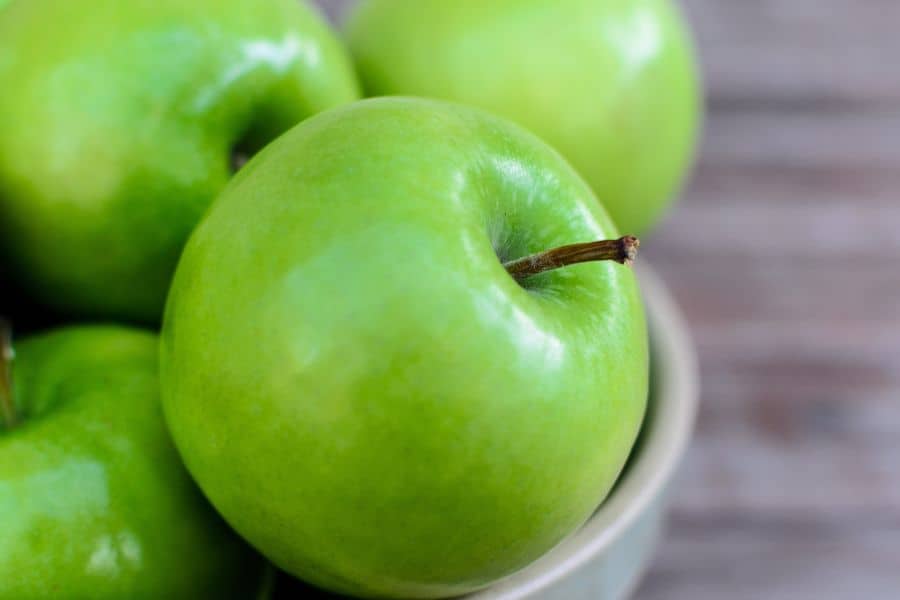Fresh healthy tart green Granny Smith apples in a bowl