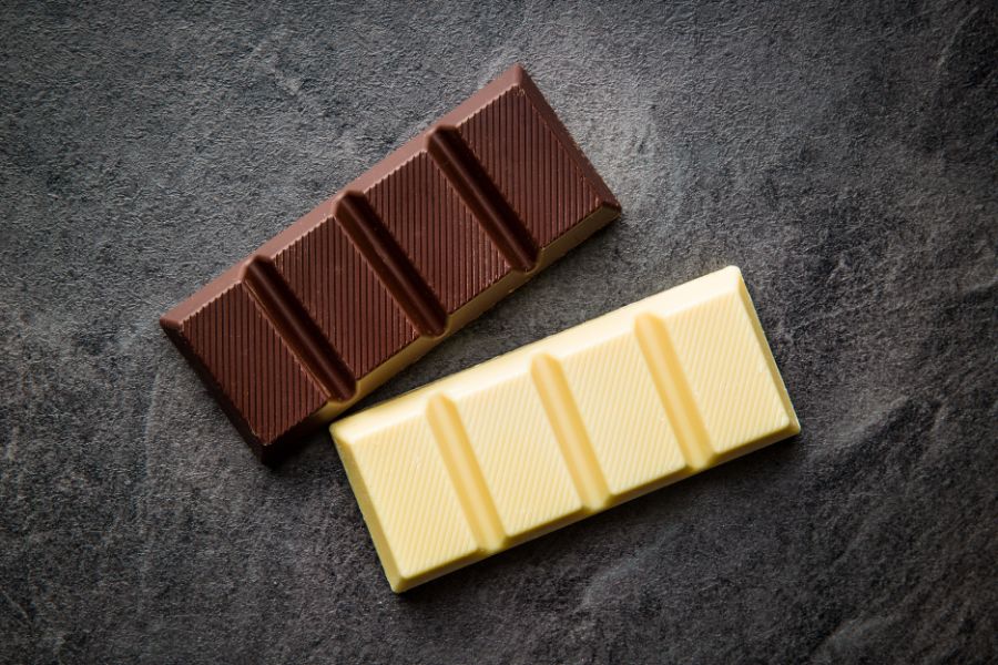 dark and white chocolate placed on a dark background